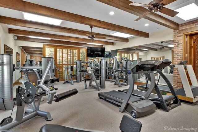 exercise room with light carpet, ceiling fan, and brick wall