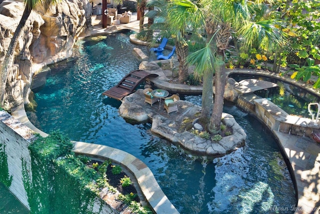 view of swimming pool with a small pond