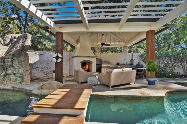 view of patio featuring area for grilling, ceiling fan, exterior fireplace, and a grill