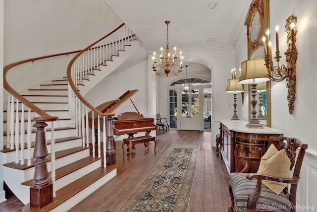 entrance foyer with a chandelier, french doors, dark hardwood / wood-style flooring, and crown molding