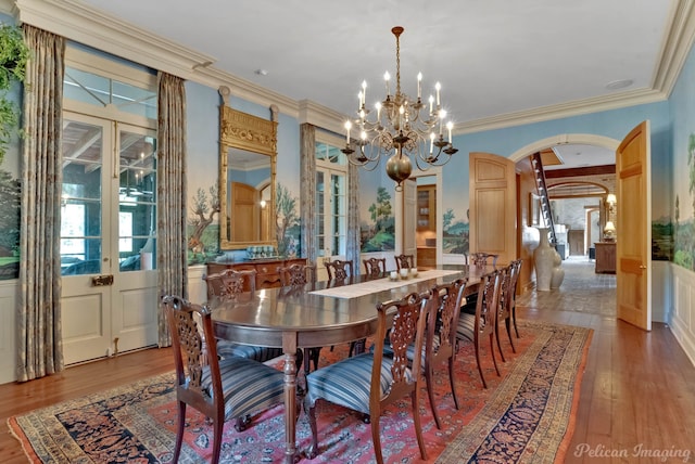 dining area with light hardwood / wood-style flooring, a chandelier, french doors, and ornamental molding