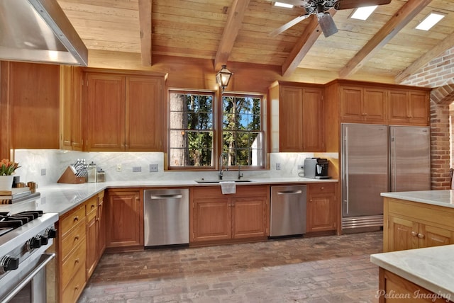 kitchen featuring brick wall, stainless steel appliances, ceiling fan, exhaust hood, and sink