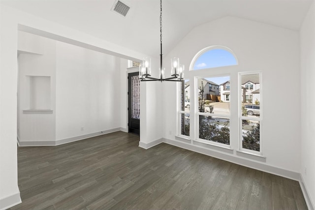 unfurnished dining area featuring dark hardwood / wood-style floors, lofted ceiling, and an inviting chandelier