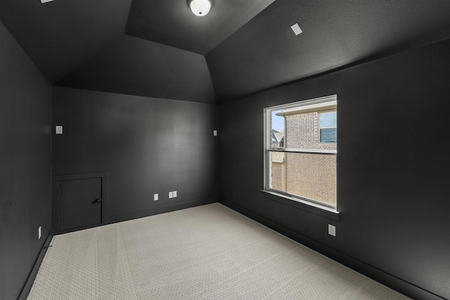 bonus room with light colored carpet and vaulted ceiling