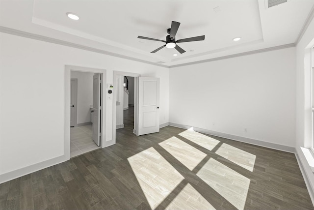 unfurnished bedroom featuring ceiling fan, dark hardwood / wood-style flooring, crown molding, and a raised ceiling