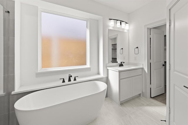 bathroom featuring vanity, tile patterned flooring, and a bathing tub