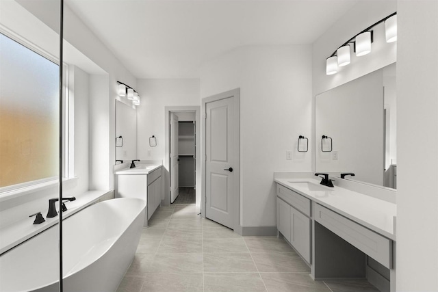 bathroom with a bath, tile patterned flooring, and vanity