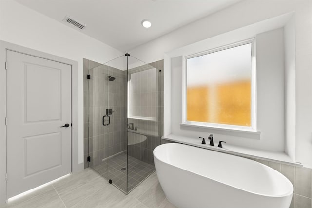 bathroom featuring separate shower and tub and tile patterned flooring