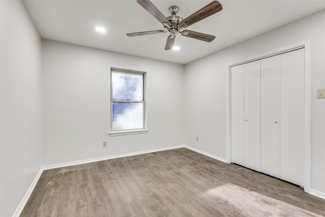 unfurnished bedroom with ceiling fan, a closet, and light hardwood / wood-style floors