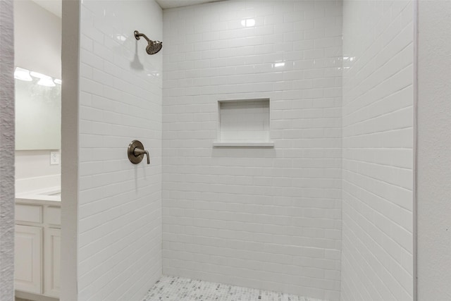 bathroom with vanity and tiled shower