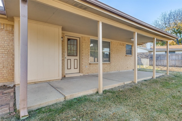 doorway to property with a patio area and a lawn