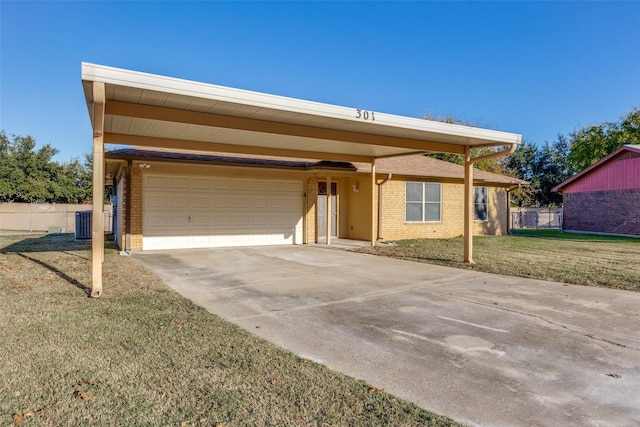 view of front of property with central air condition unit, a garage, a front yard, and a carport