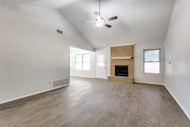 unfurnished living room featuring ceiling fan, dark hardwood / wood-style flooring, high vaulted ceiling, and a brick fireplace