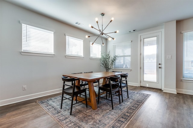 dining area with a notable chandelier, plenty of natural light, and dark hardwood / wood-style flooring