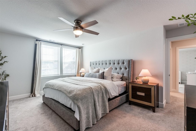 carpeted bedroom with ceiling fan and a textured ceiling