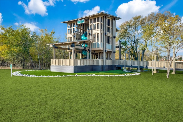 rear view of property with a playground and a yard