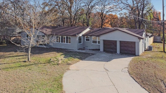 single story home featuring cooling unit, a garage, and a front lawn