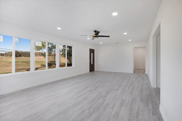 spare room with ceiling fan and light wood-type flooring