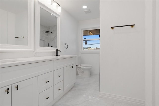 bathroom with vanity, toilet, and a shower