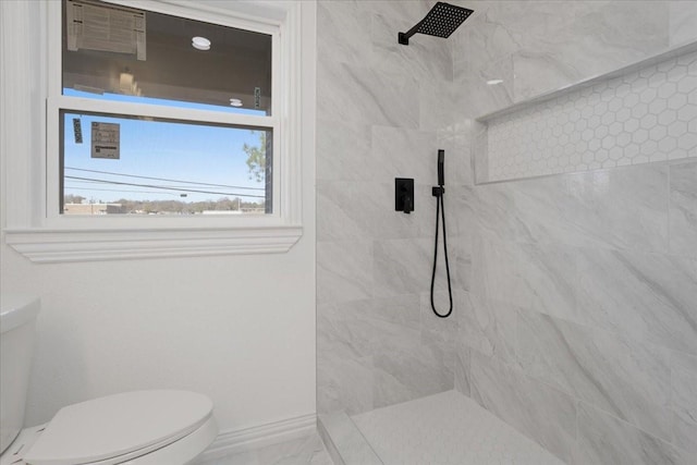 bathroom featuring tiled shower and toilet