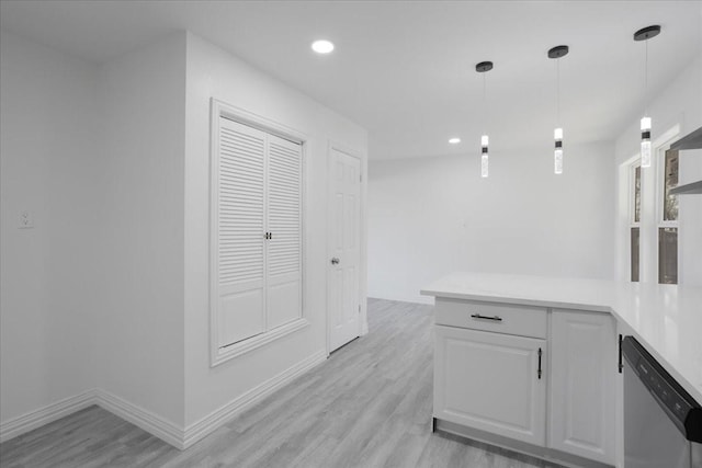 kitchen with kitchen peninsula, dishwasher, white cabinets, light hardwood / wood-style floors, and hanging light fixtures