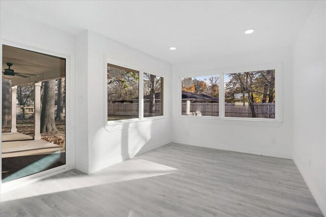 unfurnished sunroom with ceiling fan