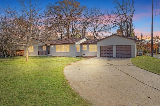 ranch-style house with a lawn, cooling unit, and a garage