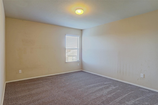 spare room with dark colored carpet