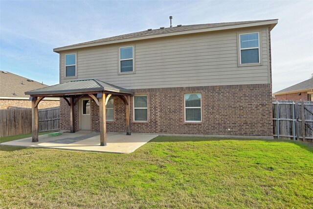 rear view of property with a yard, a gazebo, and a patio