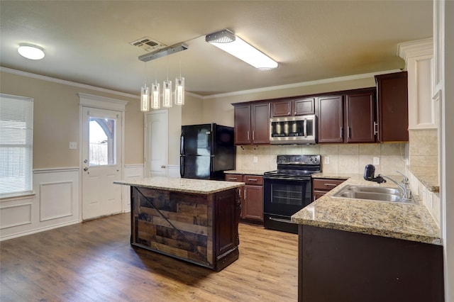 kitchen with sink, hanging light fixtures, a center island, dark brown cabinetry, and black appliances