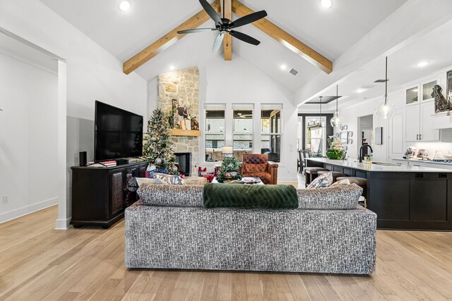 living room featuring ceiling fan, beam ceiling, sink, and light hardwood / wood-style flooring