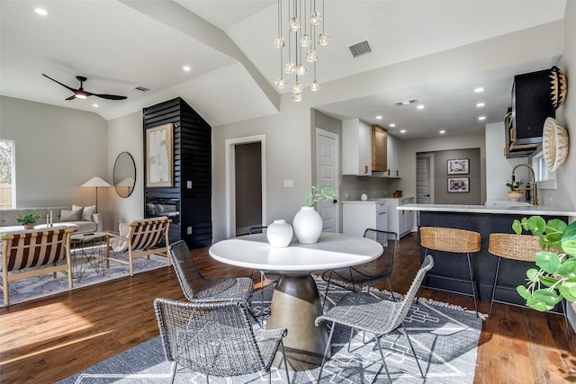 dining space featuring ceiling fan, dark wood-type flooring, lofted ceiling, and sink