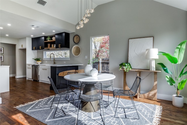 dining space featuring sink, high vaulted ceiling, and dark hardwood / wood-style flooring