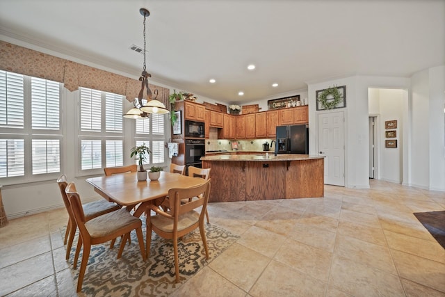 tiled dining room with a notable chandelier and ornamental molding