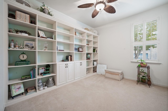 living area featuring light colored carpet and ceiling fan