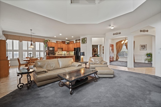 tiled living room with an inviting chandelier