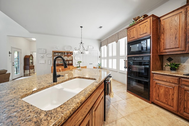 kitchen with light stone countertops, sink, decorative backsplash, black appliances, and ornamental molding