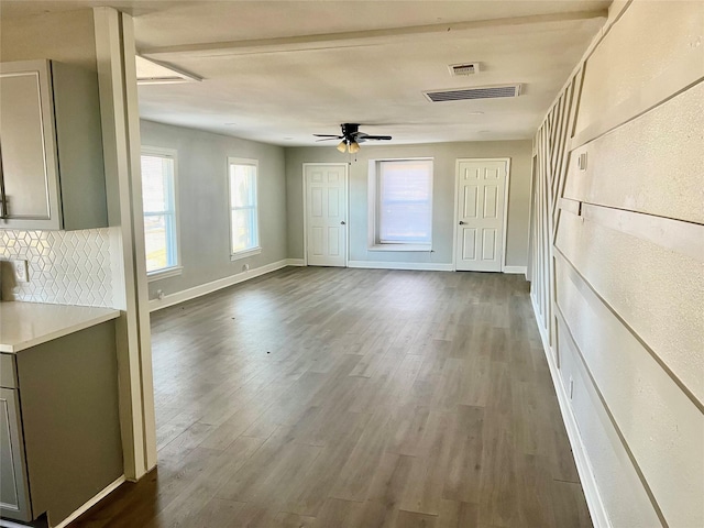 interior space with plenty of natural light, dark wood-type flooring, and ceiling fan