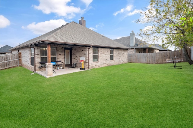 rear view of house with a yard and a patio