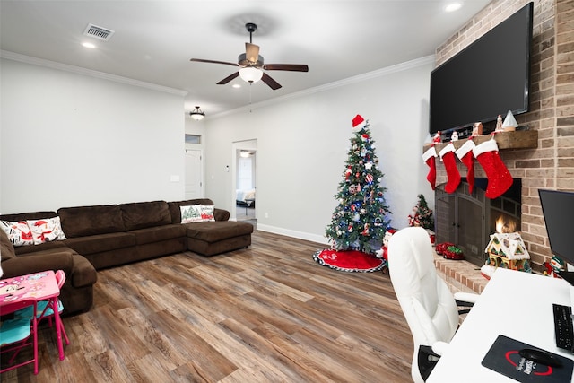 living room with a fireplace, hardwood / wood-style flooring, ceiling fan, and ornamental molding