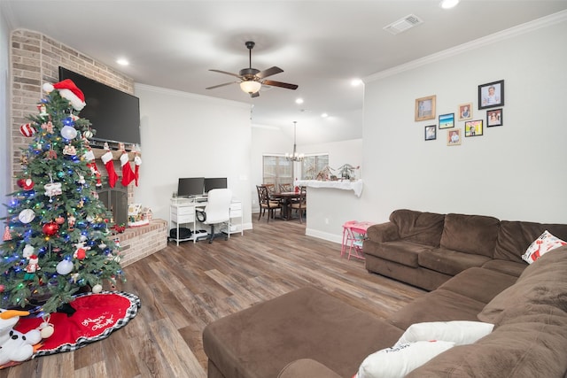 living room featuring wood-type flooring, ceiling fan with notable chandelier, and ornamental molding