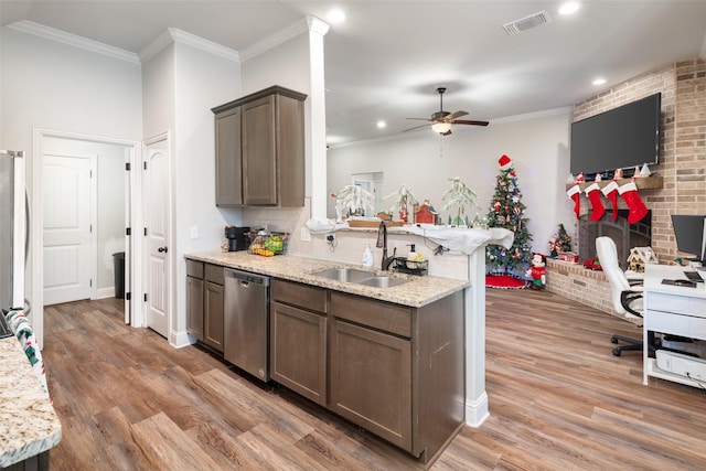 kitchen with light stone countertops, sink, stainless steel appliances, and hardwood / wood-style flooring