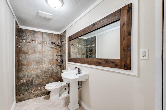 bathroom with toilet, a textured ceiling, and tiled shower