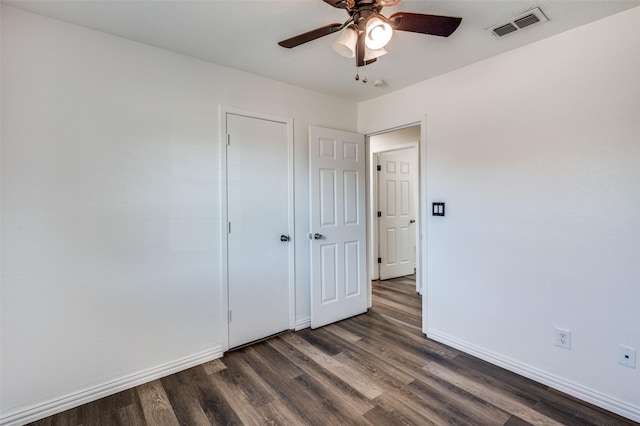 empty room with dark hardwood / wood-style flooring and ceiling fan