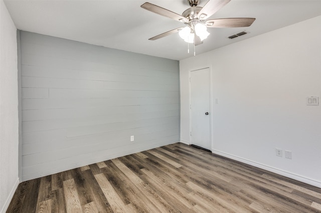 empty room with ceiling fan and dark wood-type flooring