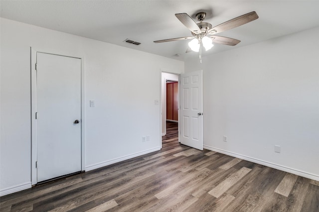 unfurnished bedroom featuring ceiling fan and dark hardwood / wood-style flooring