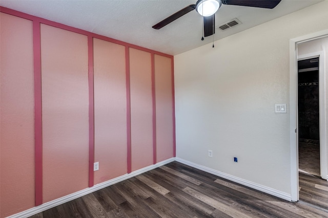 unfurnished room featuring dark hardwood / wood-style floors, ceiling fan, and a textured ceiling