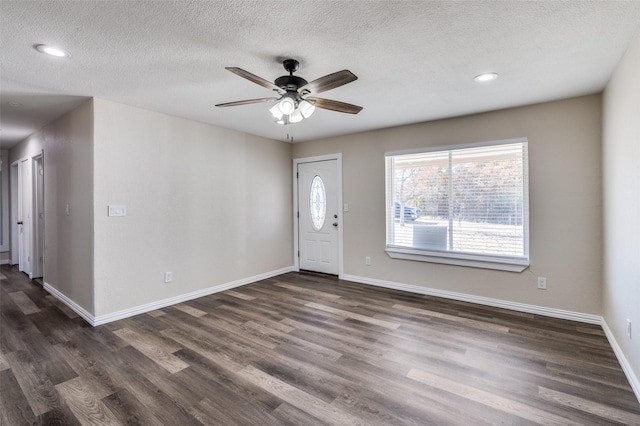 entrance foyer with a textured ceiling, ceiling fan, and dark wood-type flooring