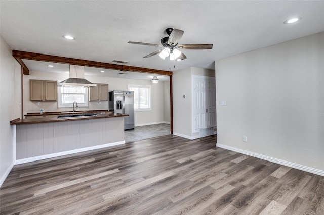 kitchen with ceiling fan, dark wood-type flooring, stainless steel fridge with ice dispenser, beamed ceiling, and range hood