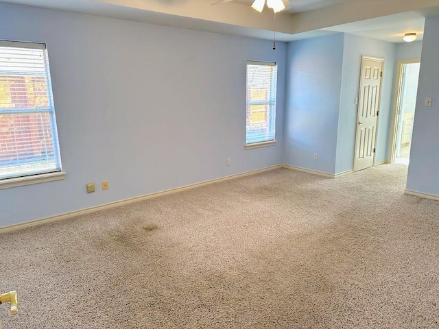 empty room with carpet, plenty of natural light, and ceiling fan